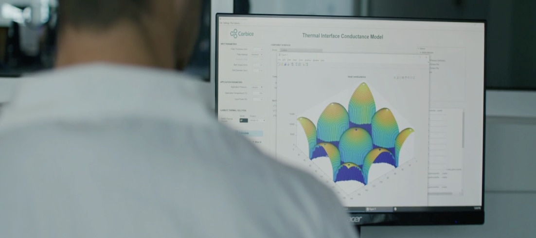 Scientist analyzing thermal interface conductance model on a computer screen in a lab
